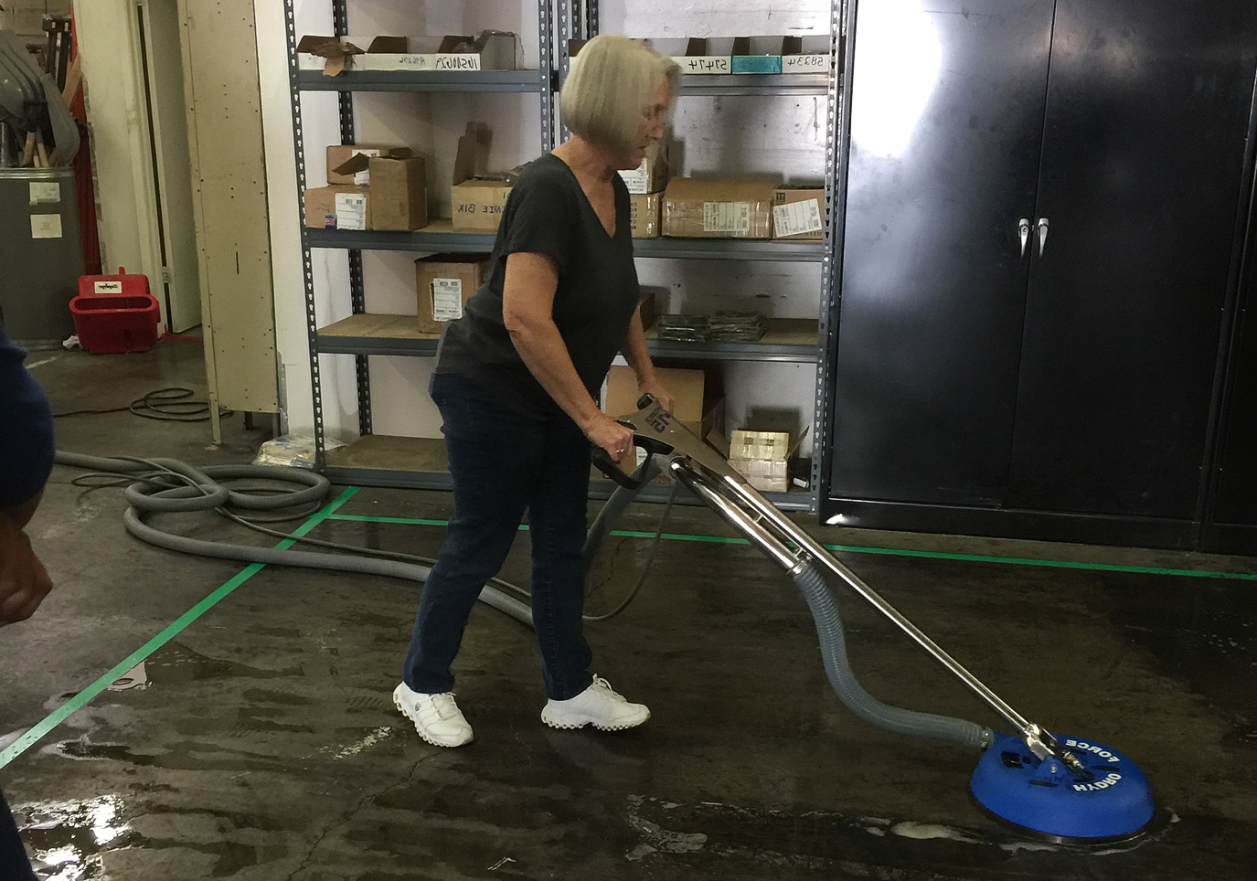 Johnson's Powerhouse Steamers technician cleaning a concrete warehouse floor