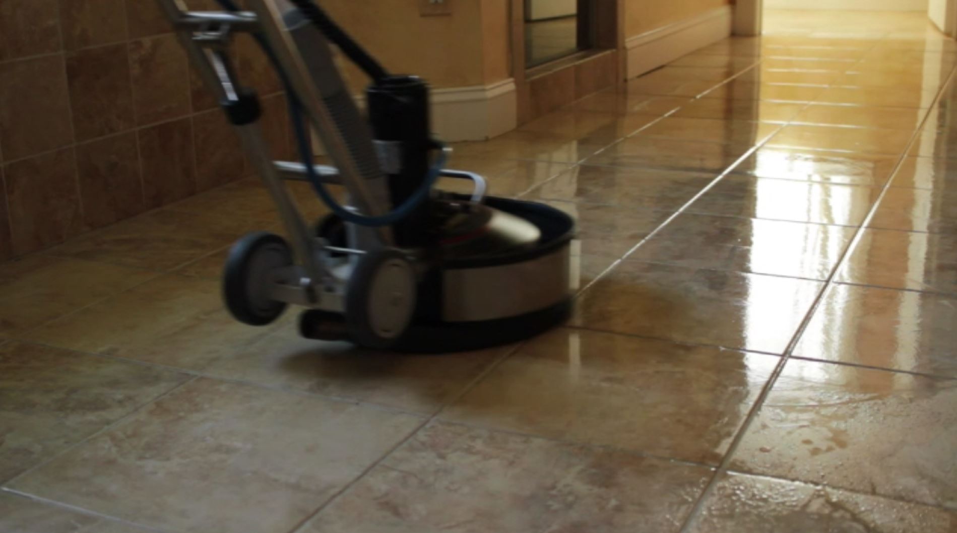 Johnson's Powerhouse Steamers tile floor buffer mid-clean showing a bright, restored tile hallway