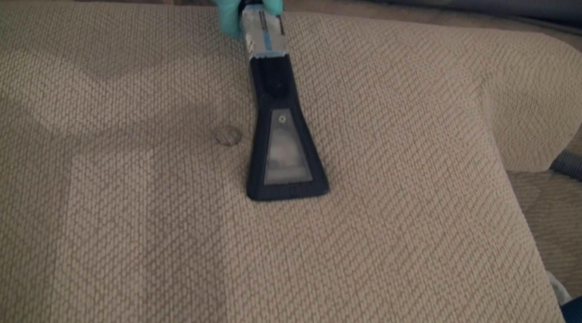 Johnson's Powerhouse Steamers upholstery cleaning tool on a fabric sofa